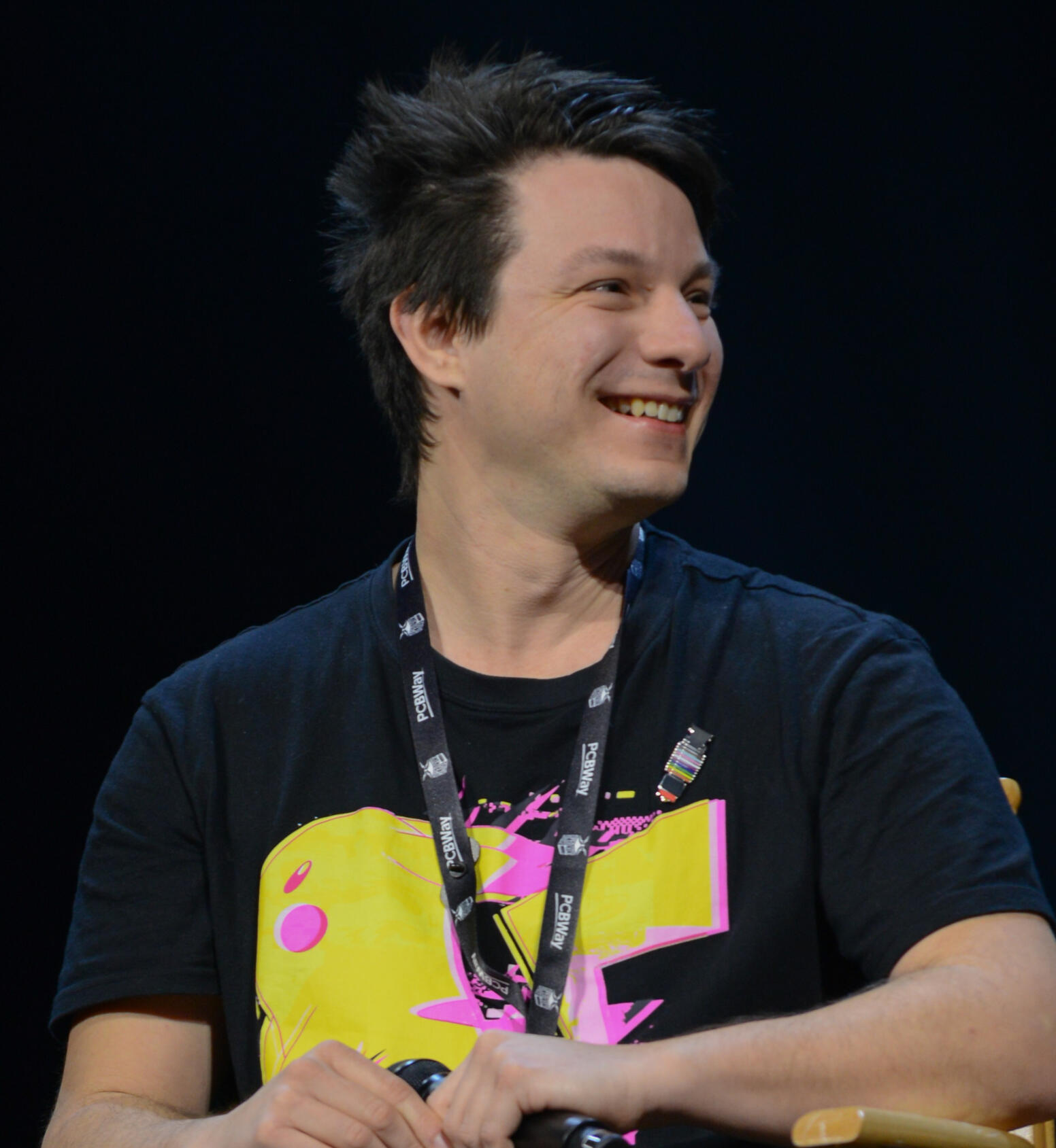 Profile shot of Angus Deveson in a black Pikachu shirt, at the Open Sauce event, at San Francisco, on the stage.